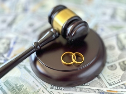 wedding rings on top of gavel and money